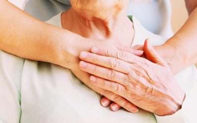 Two pairs of hands gently holding each other, symbolizing care and support.